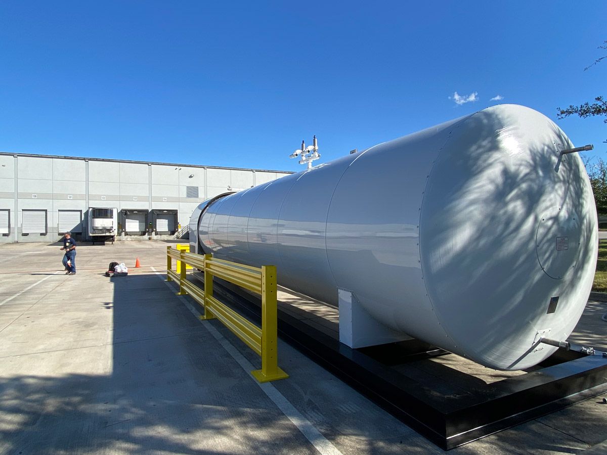 A large cylindrical tank outside a facility.
