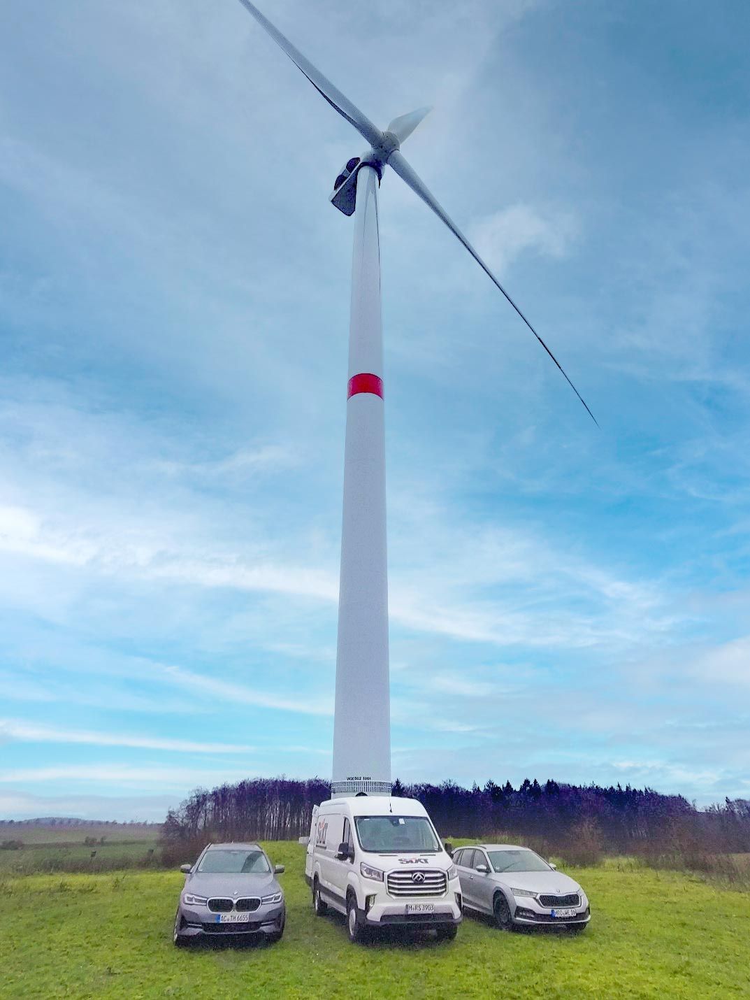 A wind turbine, seen from the ground, located in an open field.