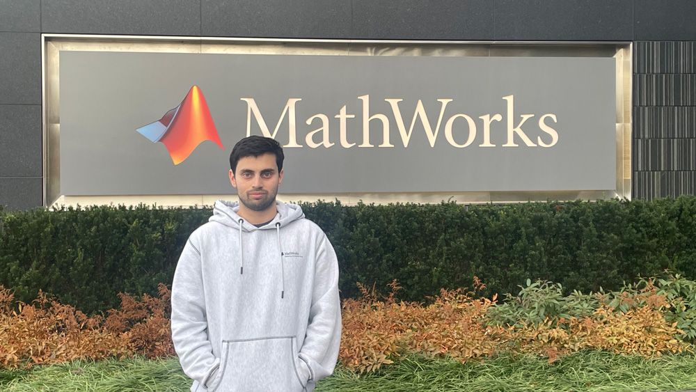 Jaydeep standing in front of the MathWorks sign outside a campus building.
