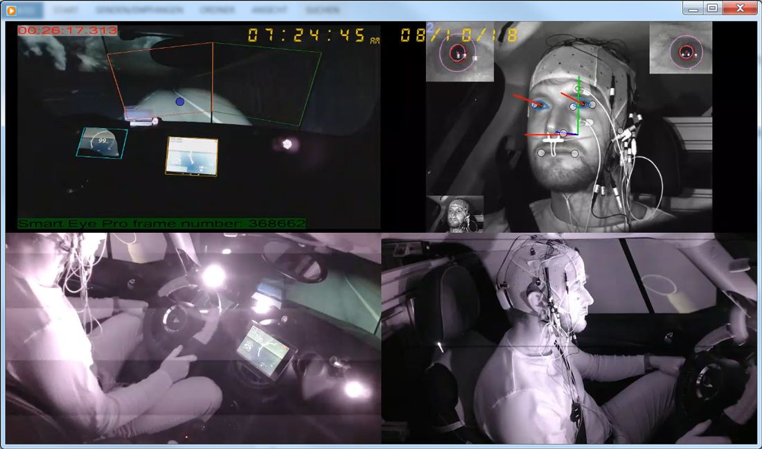 A participant in a testing car at night with an E C G and other equipment to monitor heart activity, eye movement, gaze direction, and pupil dilation.
